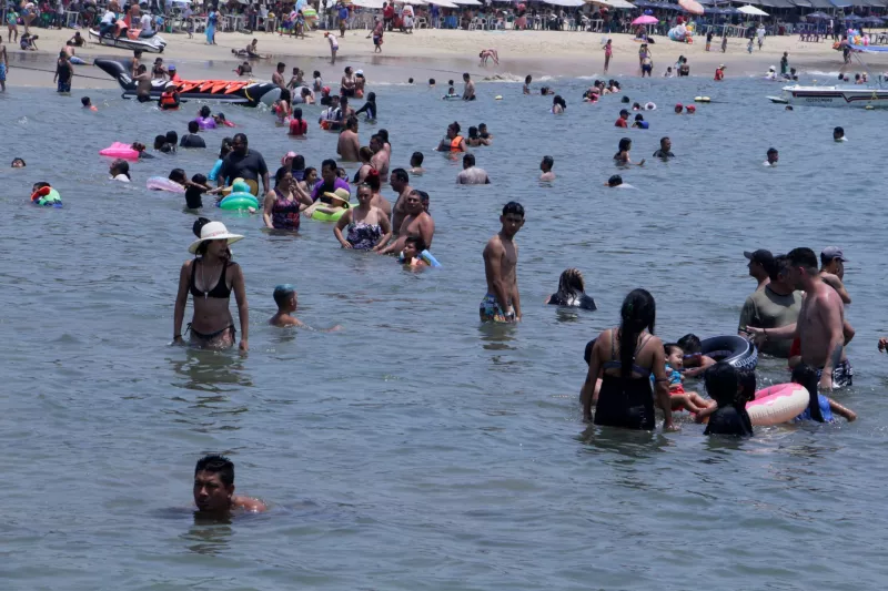 Cofepris analizó cuales son las playas limpias en México.  (Playa en Acapulco con varias personas en el mar). 