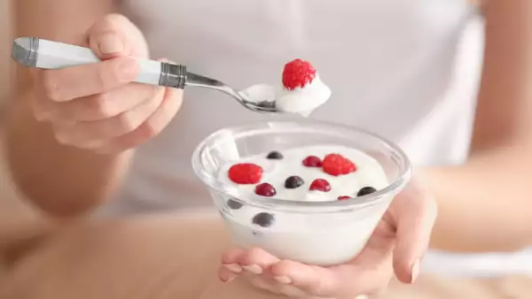 Young woman eating yogurt, closeup