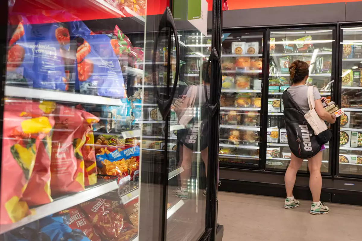 (Mujer viendo productos congelados en los refrigeradores de un supermercado en Nueva York)