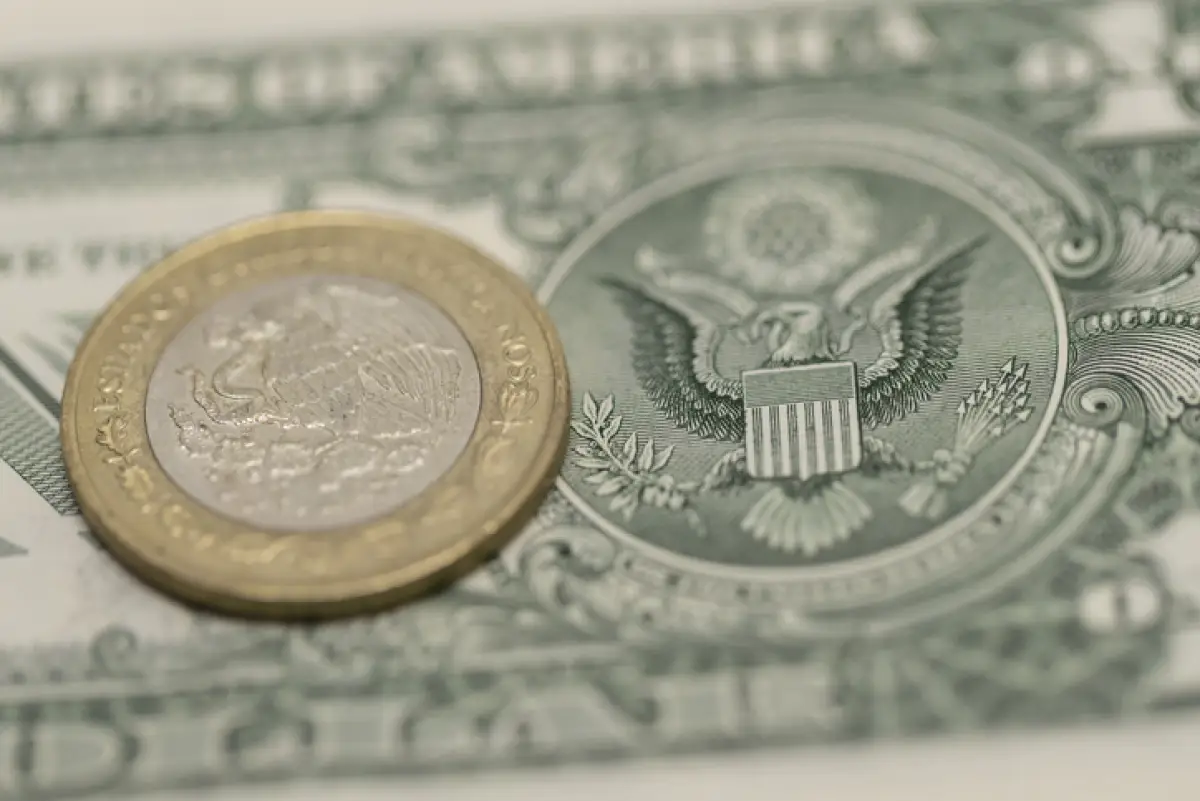 Una moneda de 10 pesos sobre el reverso de un dólar.