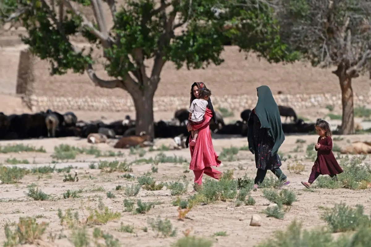 En esta foto tomada el 4 de junio de 2023, las mujeres caminan con sus hijos en el pueblo de Kandali en el distrito de Sholgara de la provincia de Balkh.