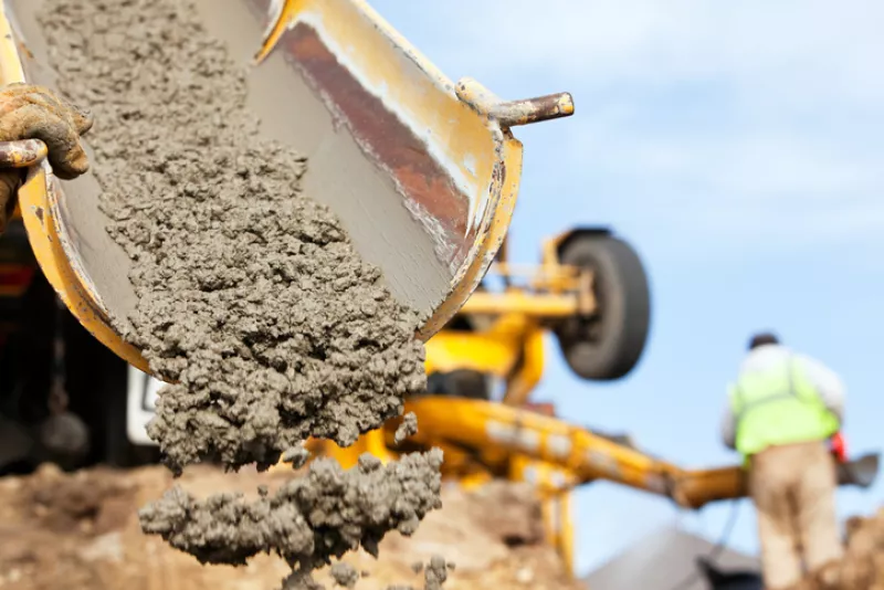 Construction Worker Guiding Cement Mixer Truck Trough