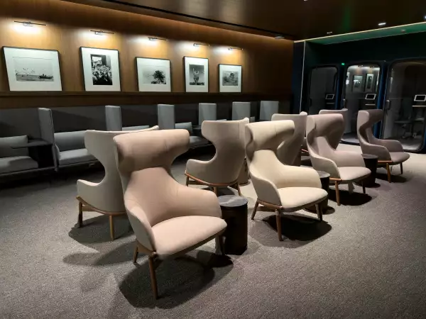 Interior de sala premier de Aeroméxico se observan unas sillas y cuadros con fotos en una pared