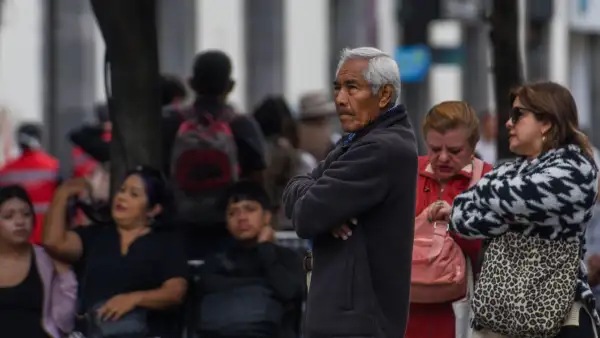Adultos mayores en la calle entre jóvenes.