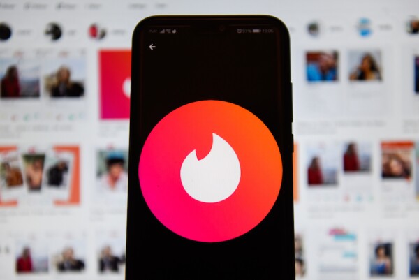 In this photo illustration a Tinder logo seen displayed on a
