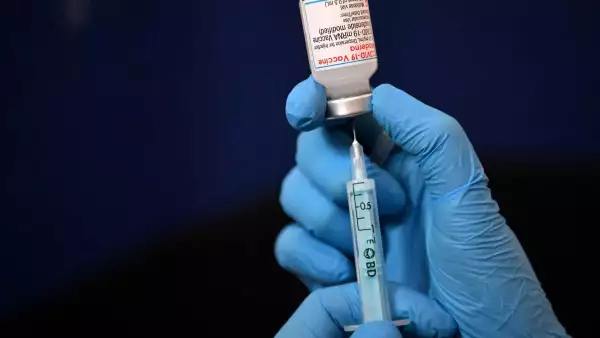 La vacunación obligatoria debe ser el último recurso (Manos de personal médico, sostienen una jeringa que contiene la vacuna contra covid 19)