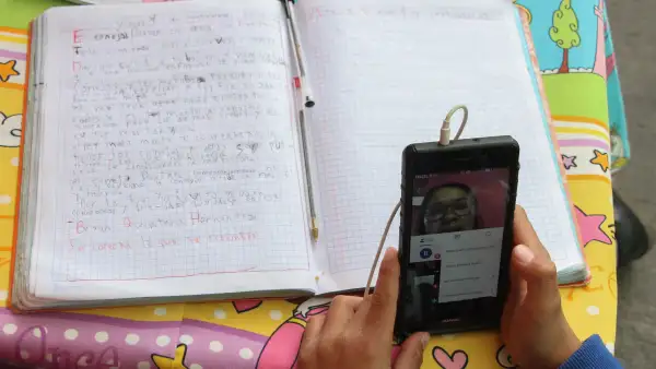 Un estudiante utiliza un celular para tomar clases.