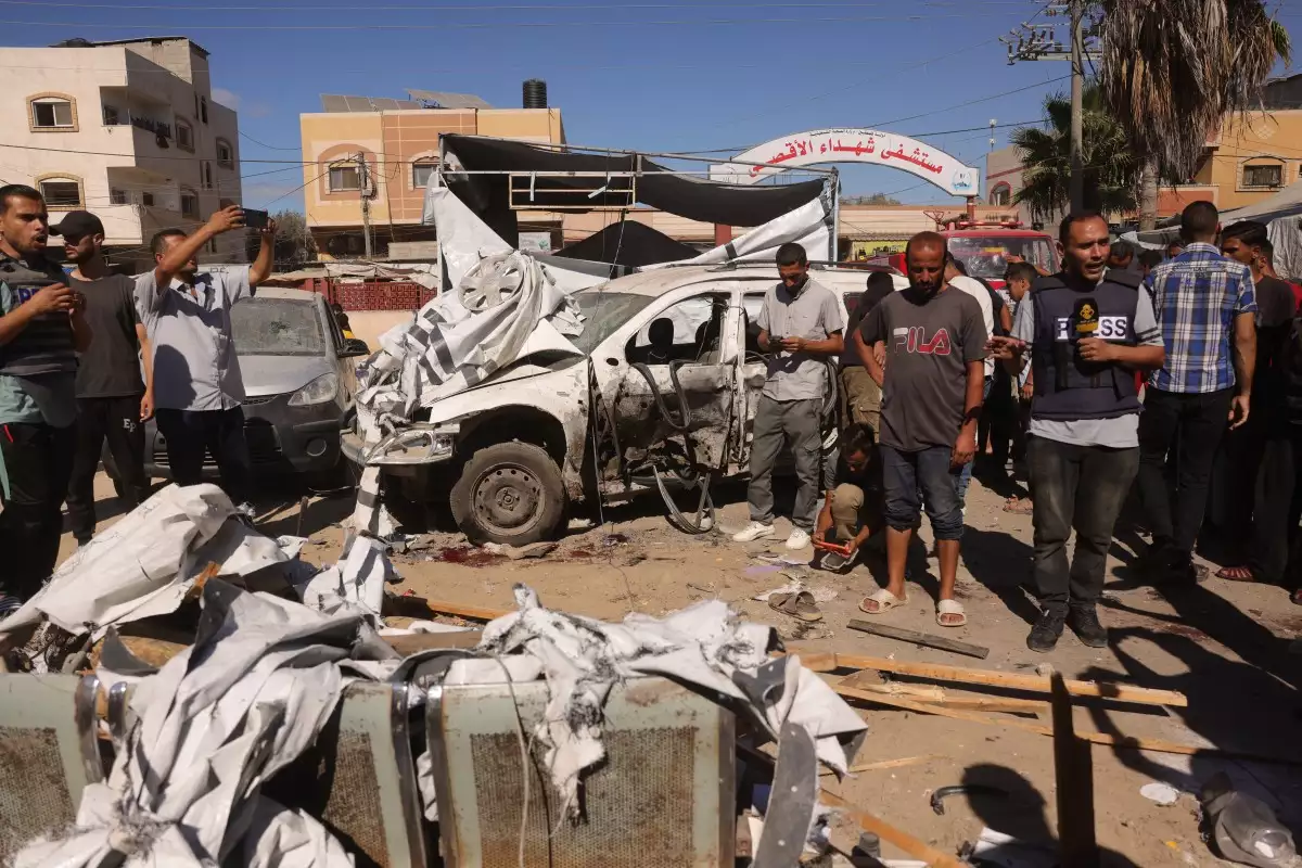 Un periodista de televisión informa desde la escena de un ataque israelí que golpeó una tienda de campaña utilizada por palestinos desplazados dentro de la vecindad del Hospital Shuhada al-Aqsa (Ártires de Aqsa) en Deir al-Balah, en el centro de la Franja de Gaza, el 1 de octubre de 2025, en medio del continuo conflicto entre Israel y Hamas.