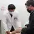 Un médico que viste bata blanca revisa la pierna de un paciente. 