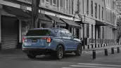 SUV Ford Explores ST modelo 2025 en color azul pálido se desplaza sobre una calle citadina, de una urbe indeterminada