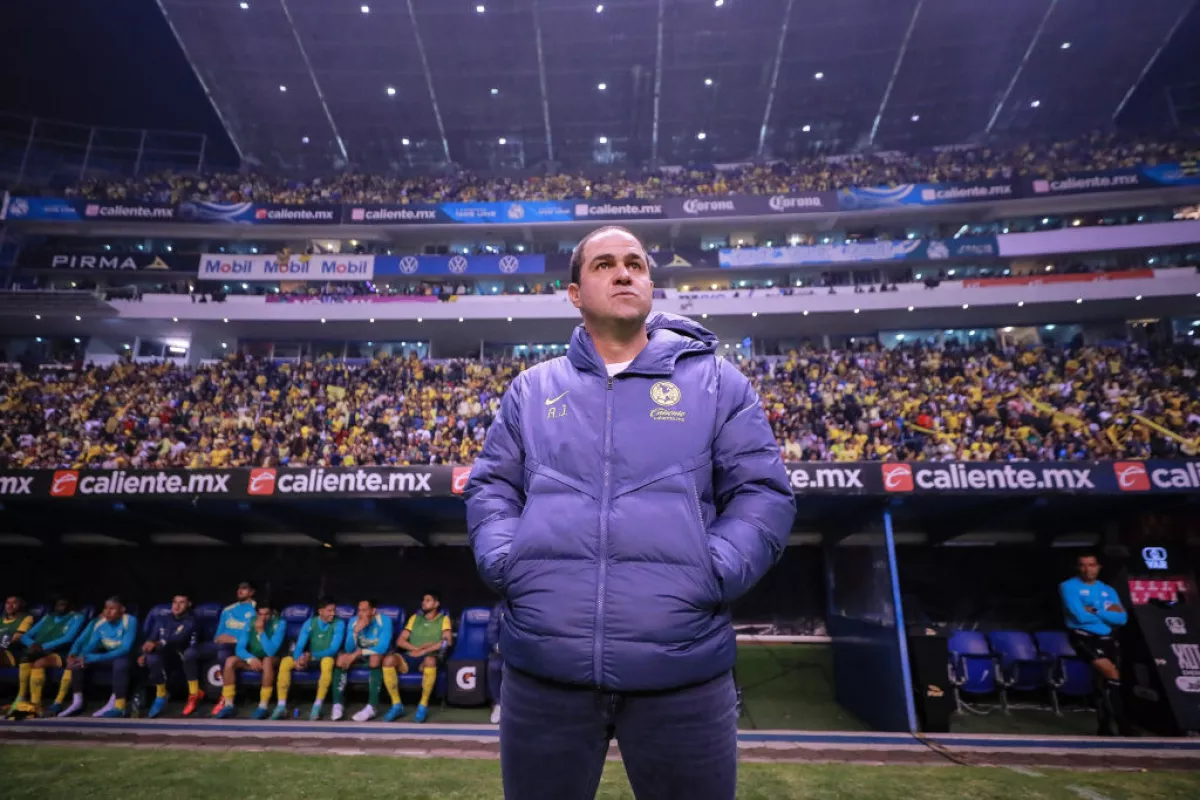 Foto de André Jardine, entrenador del América, parado en el campo de juego, con un estadio Cuauhtémoc (en Puebla) completamente lleno.