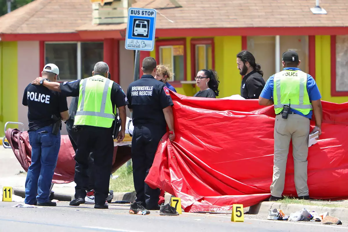 Un oficial de policía es consolado después de un incidente mortal en el que un coche se topó con peatones cerca del Ozanam Center, un refugio para migrantes y personas sin hogar, en Brownsville, Texas, EE. UU., el 7 de mayo de 2023.