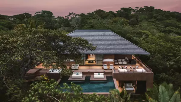 Foto del edificio principal de One&Only Mandarina en medio de la selva nayarita con alberca y camastros.