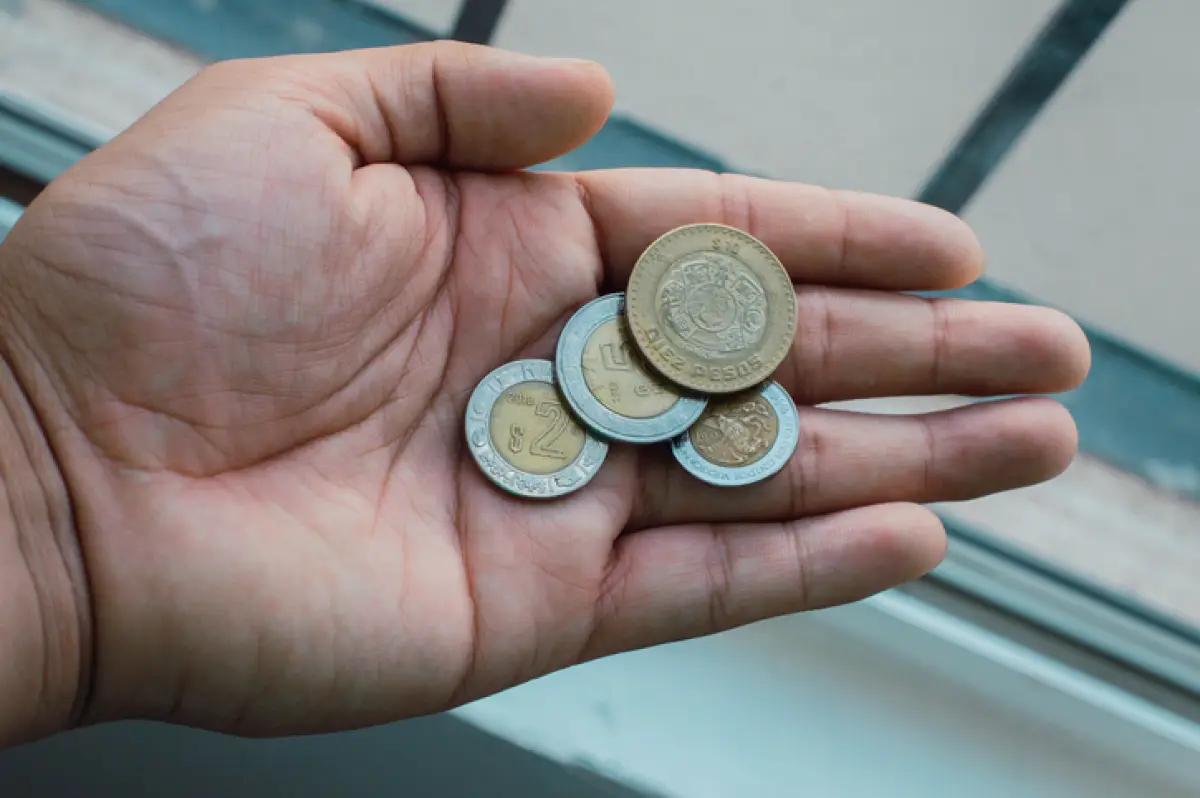 Coins in the palm of your hand. Mexican pesos on the hand of adult man.