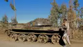 Qué va a ocurrir en Etiopía tras el anuncio de repliegue de los rebeldes (Un hombre camina junto a un tanque militar)
