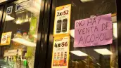 Dos refrigerados con un cartel rosa en donde dice que no hay venta de alcohol. Fotos con botellas de whiskey y caribe cooler.jpg