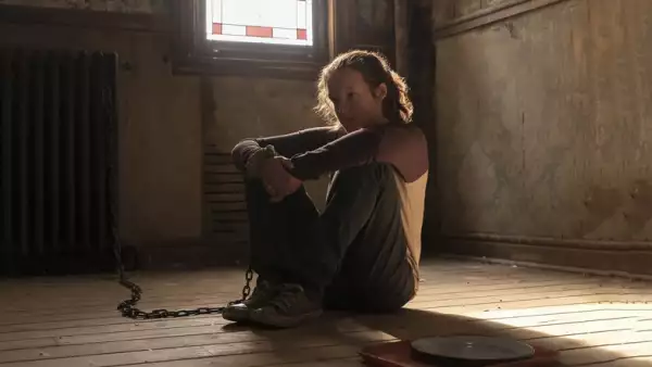 Foto de Ellie (Bella Ramsey) encadenada en una habitación con pisos de madera en una escena de la serie The Last Of Us.