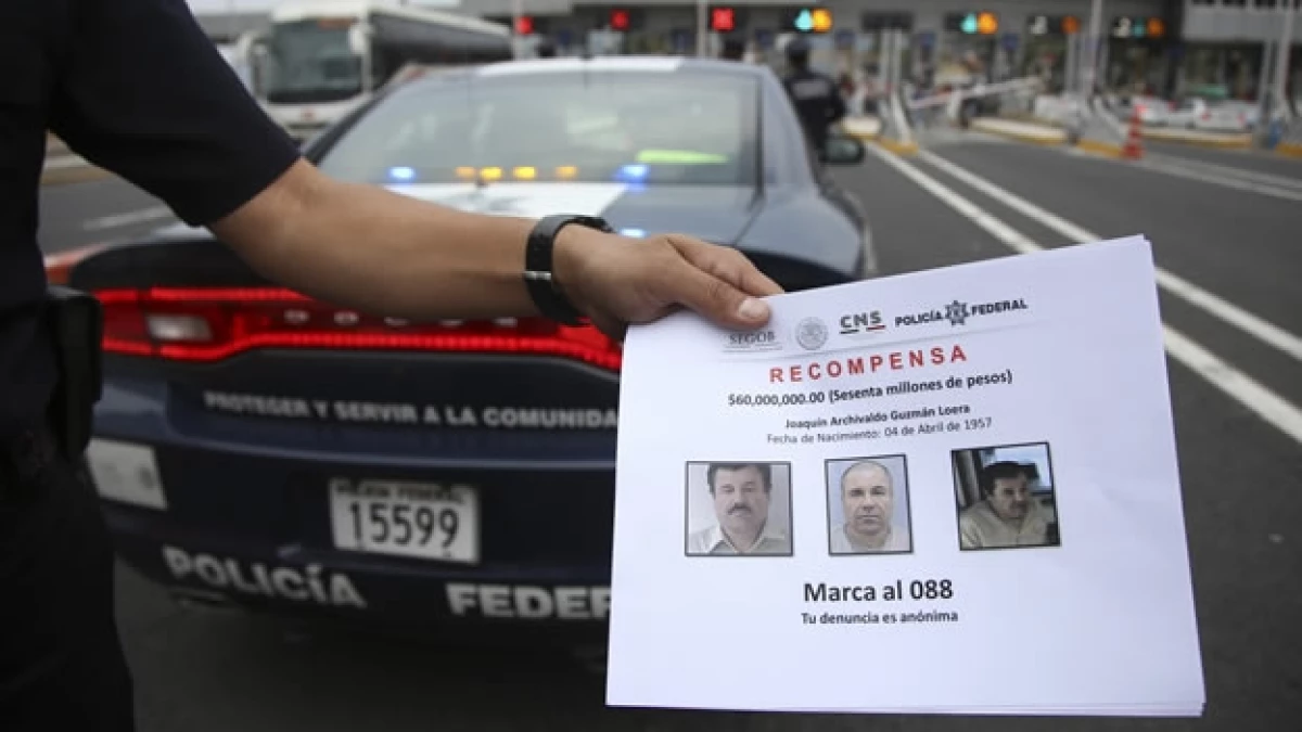 Elementos de la Policía Federal muestran folletos entregados a la ciudadanía para que puedan aportar información sobre Joaquín Guzmán