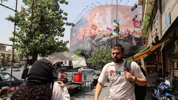 Los iraníes pasan junto a una valla publicitaria antiestadounidense en la plaza Enghelab, en el centro de Teherán, el 3 de agosto de 2026. Irán negó que se estuvieran llevando a cabo negociaciones con los Estados Unidos después de que el presidente de los Estados Unidos dijera que las nuevas conversaciones comenzarían el 3 de agosto en un esfuerzo por poner fin a su guerra, ahora en su sexto mes.