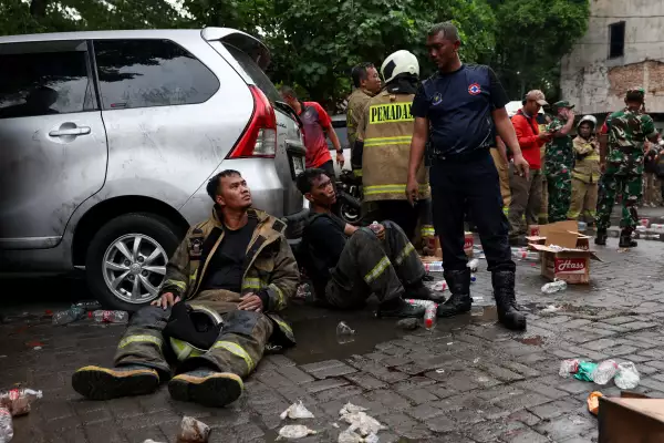 Los bomberos descansan cerca de un edificio de siete pisos dañado por un incendio en Yakarta, Indonesia, el 9 de diciembre de 2025.