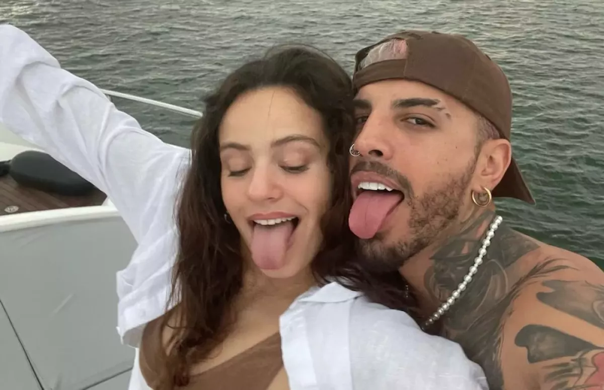 Rosalía y Rauw Alejandro en un bote mientras Rosalía saca la lengua.