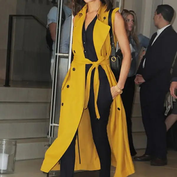Posh spice avivó su look con una cabardina sin mangas color mostaza de la colección pre-spring 2017 de su firma homónima.