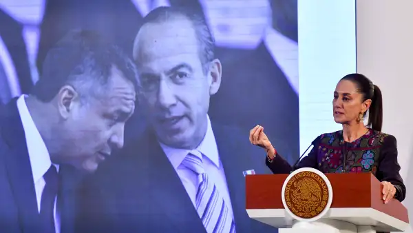 En la imagen, la presidenta Claudia Sheinbaum durante su conferencia matutina y al fondo una imagen de Genaro García Luna y Felipe Calderón