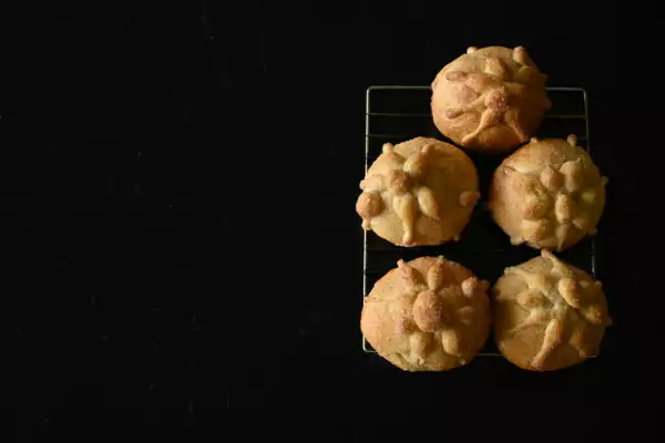 Top view of freshly baked pan de muerto on black background