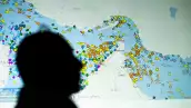 Una ilustración fotográfica tomada en Nicosia el 4 de mayo de 2026, muestra a una persona frente a una gran pantalla que muestra los movimientos de los buques en el Estrecho de Ormuz en un sitio web de seguimiento de buques. Teherán anunció que estaba cerrando el Estrecho de Ormuz el 12 de julio y lanzó misiles y drones a sus vecinos del Golfo, en represalia por los nuevos ataques estadounidenses después de un ataque de las fuerzas iraníes a un buque mercante que fue abandonado en llamas por su tripulación.