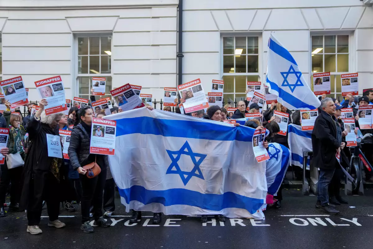 Los manifestantes sostienen banderas de Israel mientras forman una cadena humana fuera de la embajada de Qatar en una protesta que pide la liberación de los rehenes israelíes en manos de Hamas en Londres, Gran Bretaña, el 29 de octubre de 2023.