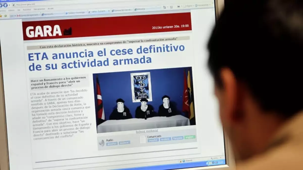 Un hombre mira Gara, donde ETA anuncia el cese a la violencia