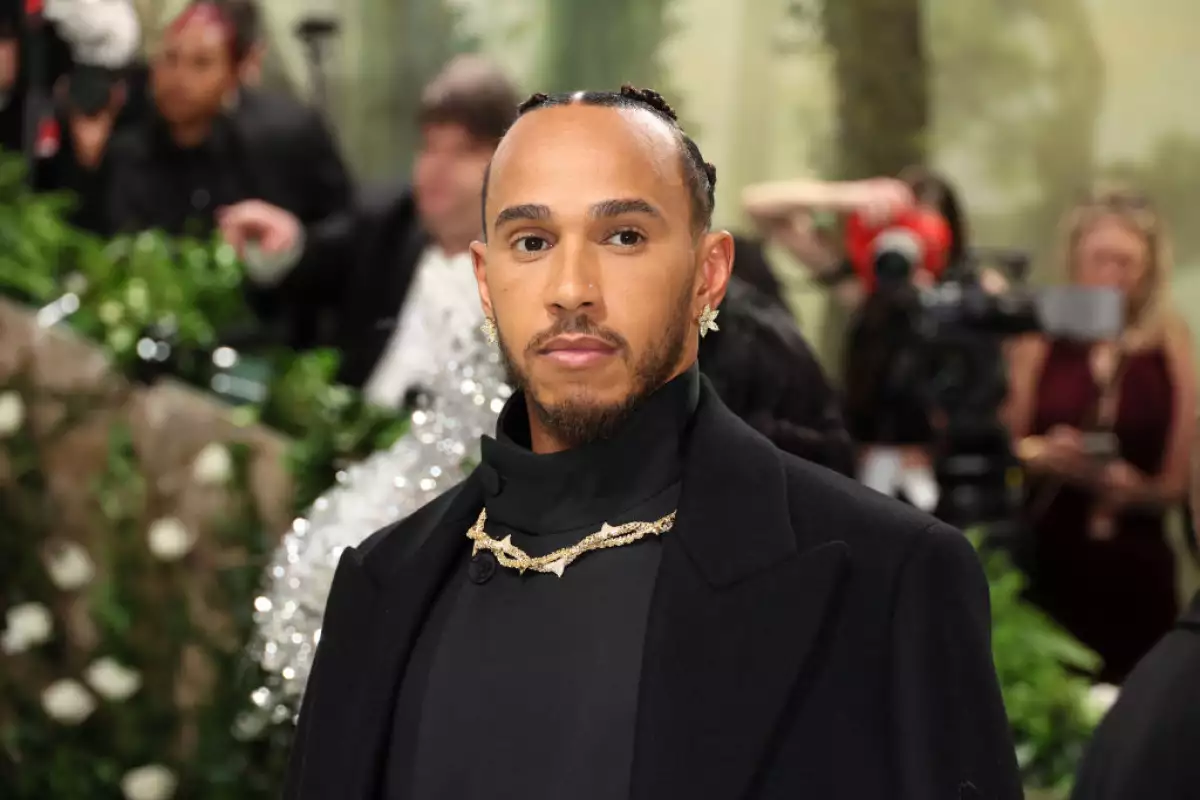 foto de lewis hamilton en la met gala 2024 usando un collar llamativo y aretes de flores
