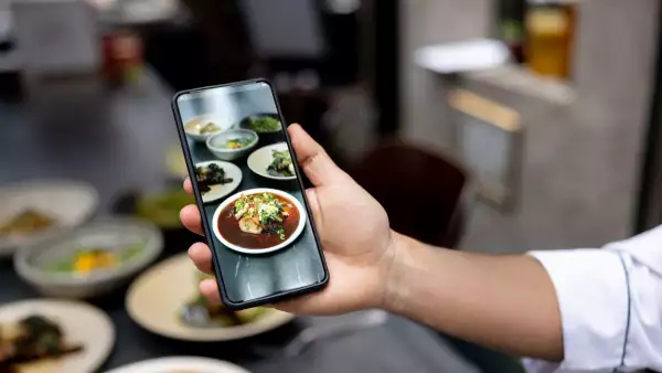 Chef tomando foto a uno de los platillos en la mesa