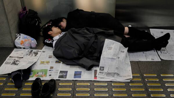 Varias personas duermen en el Tokio International Forum, un centro de espectáculos adaptado como un refugio temporal.