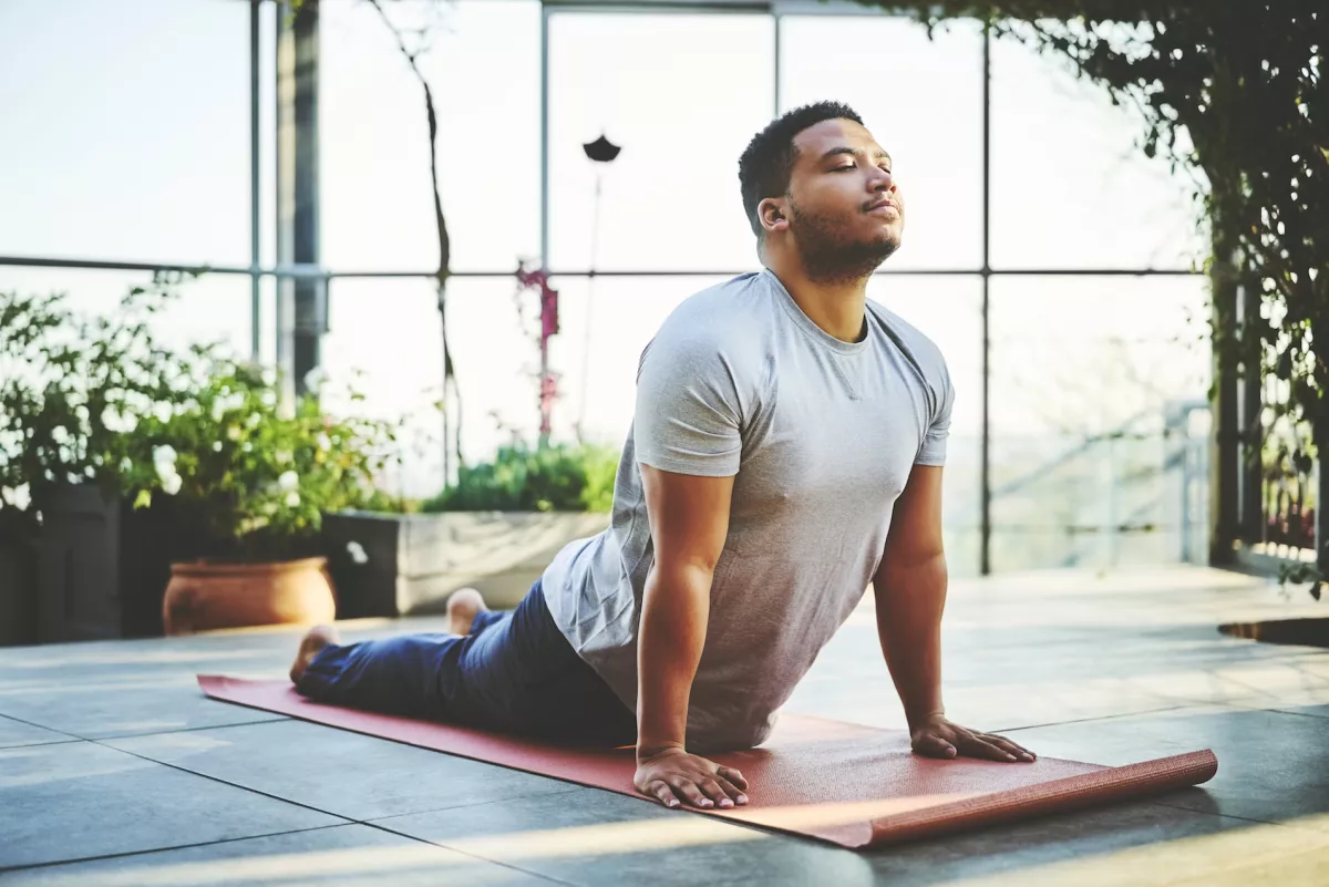 Young man practicing Upward Facing Dog Pose