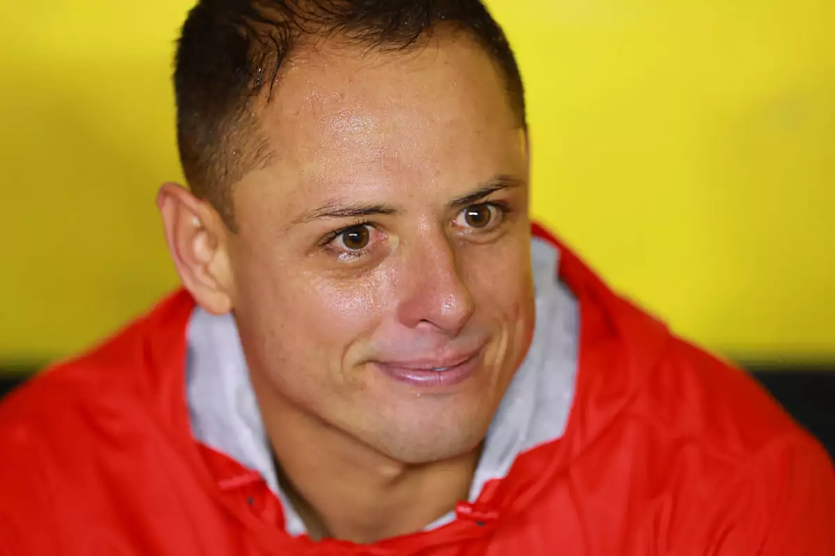 Foto de Javier Chicharito Hernández durante un partido América-Chivas el 13 de septiembre de 2025, viste chamarra roja y tiene una expresión de tristeza.
