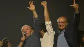 Lula da Silva levanta mano izquierda en la cual se observa la falta de su dedo meñique. Lo acompaña el vicepresidente.jpg