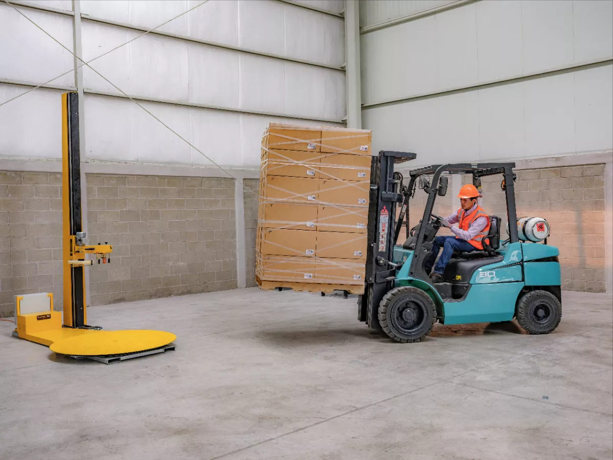 Un trabajador está transportando un paquete fácilmente gracias al sistema de paletizado Stretchable Tape 