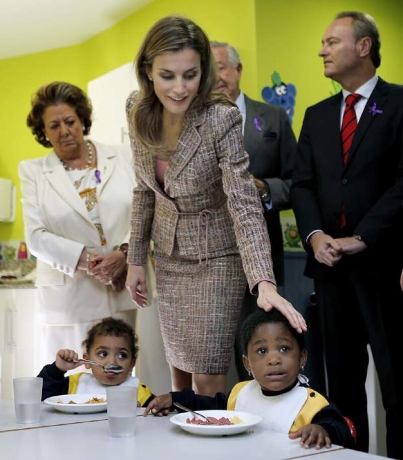 La princesa acarició y demostró afecto a los niños que comían.