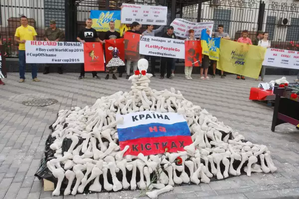 Los activistas sostienen carteles del artista Andriy Yermolenko durante un mitin con un llamamiento para boicotear el torneo de fútbol de la Copa Mundial de Rusia 2018, y exigen la liberación del director ucraniano Oleg Sentsov y otros prisioneros políticos ucranianos en Rusia, cerca de la Embajada de Rusia en Kiev, Ucrania, el 14 de junio de 2018.