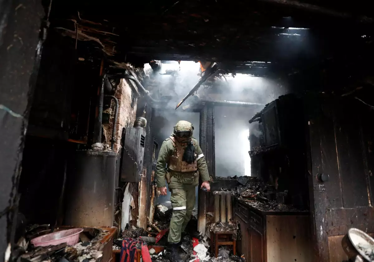 Un soldado de las milicias pro-rusia camina dentro de una casa que fue dañada en un bombardeo reciente en Donersk, Ucrania. 