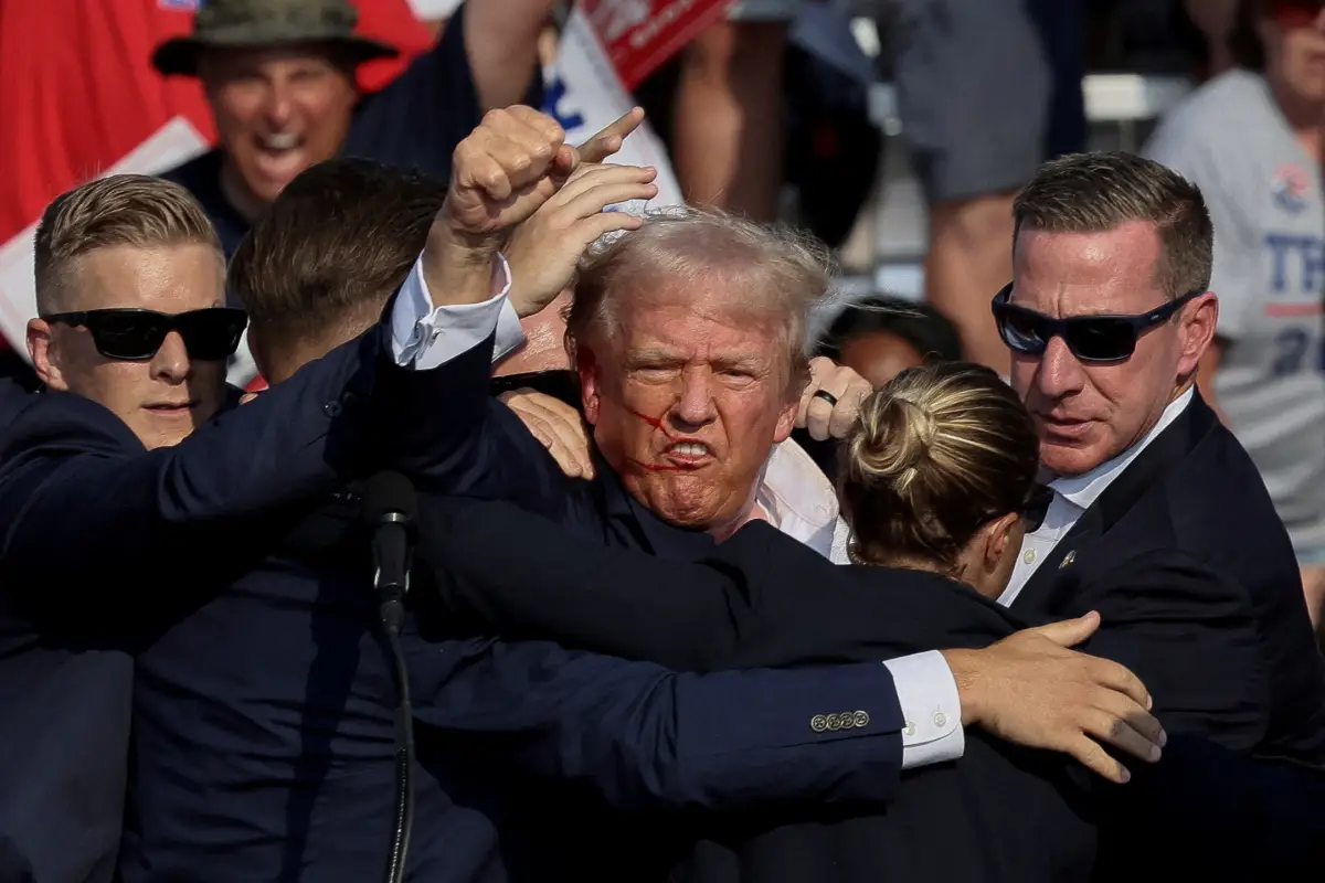 El candidato presidencial republicano y expresidente de los Estados Unidos, Donald Trump, es asistido por el Servicio Secreto después de que se disparara durante un mitin de campaña en el Butler Farm Show en Butler, Pensilvania, EE. UU., el 13 de julio de 2024.