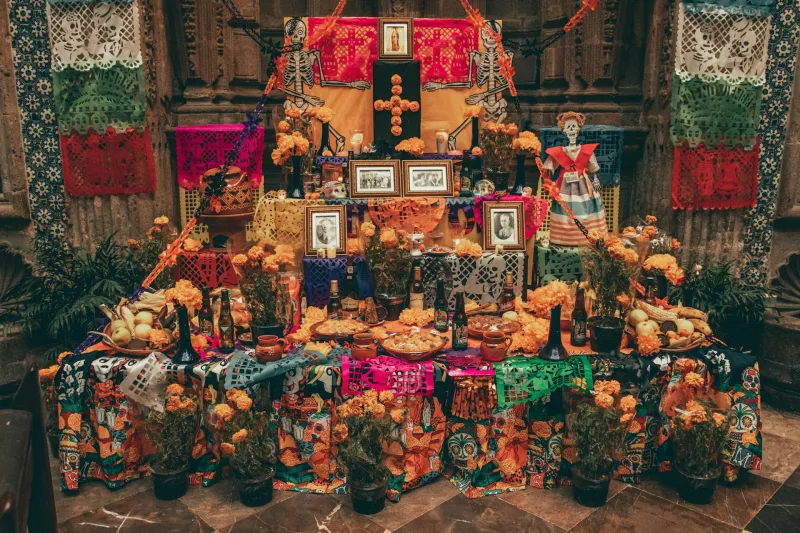 Ofrenda de Día de Muertos con las fotos de las personas fallecidas. 