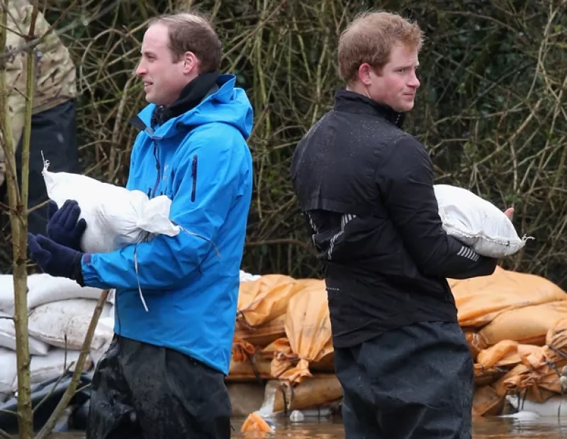 Los príncipes, junto a un grupo de la armada británica, asistieron a una comunidad severamente afectada por las lluvias. En el camino, Guillermo invitó a un reportero a ayudar en lugar de grabarlos.