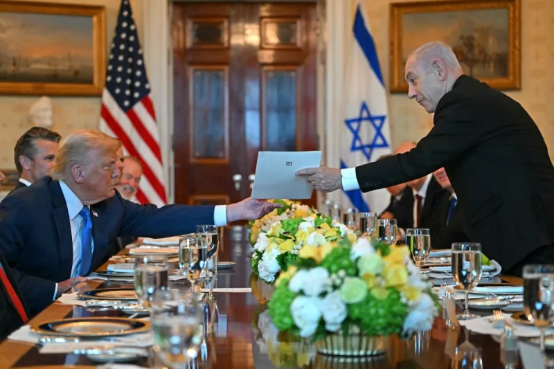 El primer ministro israelí Benjamin Netanyahu (R) entrega una carta al presidente estadounidense Donald Trump mientras se reúnen en la Sala Azul de la Casa Blanca en Washington, DC, el 7 de julio de 2025.