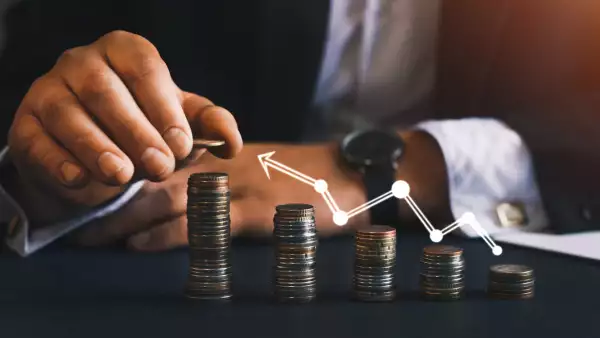 hombre en trahe reganfo una planta con monedas de base