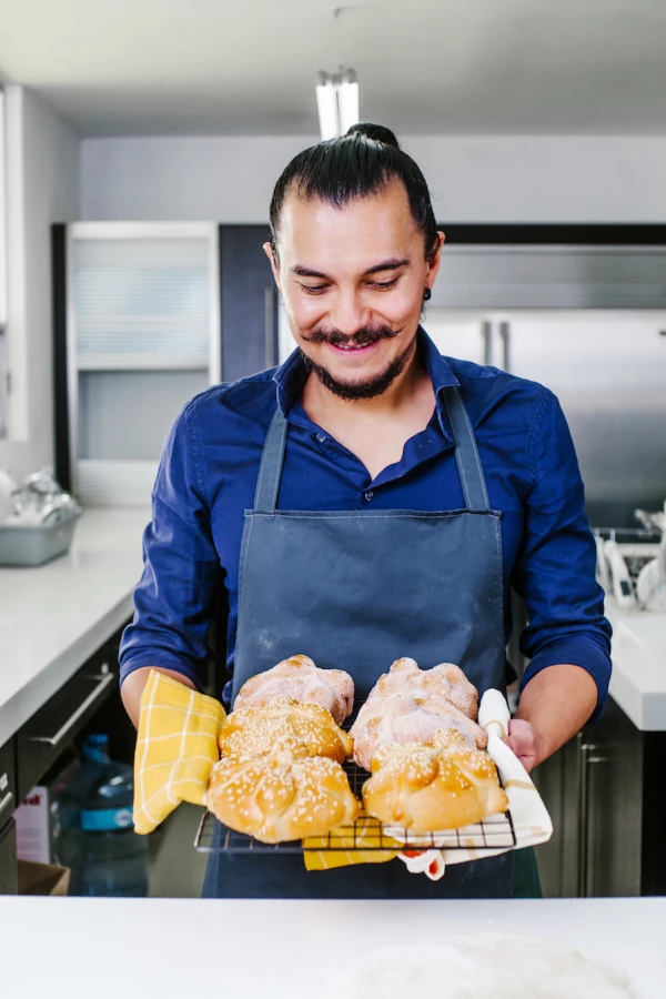 Mexican man cooking Pan de Muerto Traditional bread for day of the dead in Mexico
