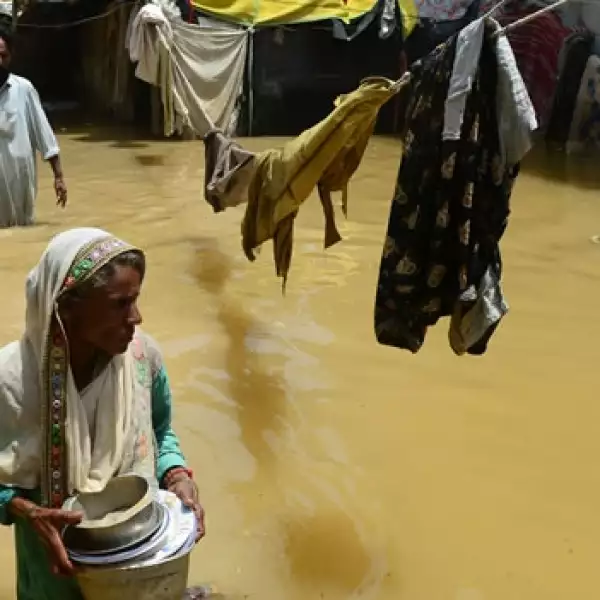 una mujer cambina entre el agua en karachi