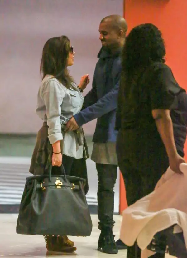 Kanye acomodó la sudadera de su pareja mientras le sonreía.