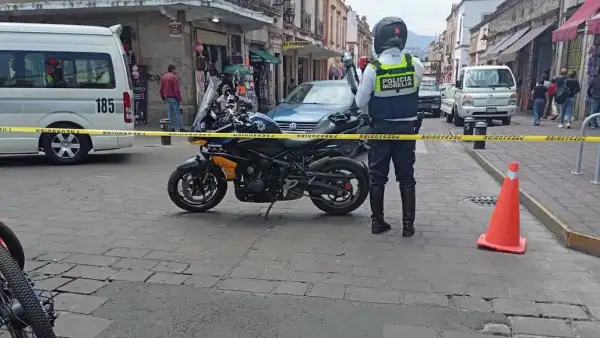 Policía municipal de Morelia junto a su motocicleta cierra la circulación vial. 